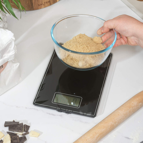 Black digital kitchen scale with LCD display, shown from angled view