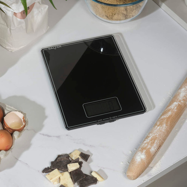 Digital kitchen scale with glass surface showing close-up of display and buttons