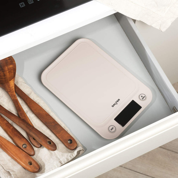 Beige Salter digital kitchen scale in drawer beside wooden spoons
