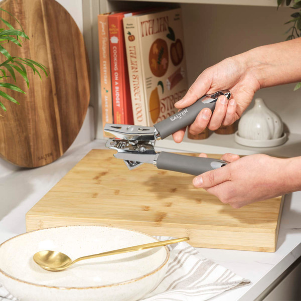 Salter manual can opener with black handles, shown in a modern kitchen setting