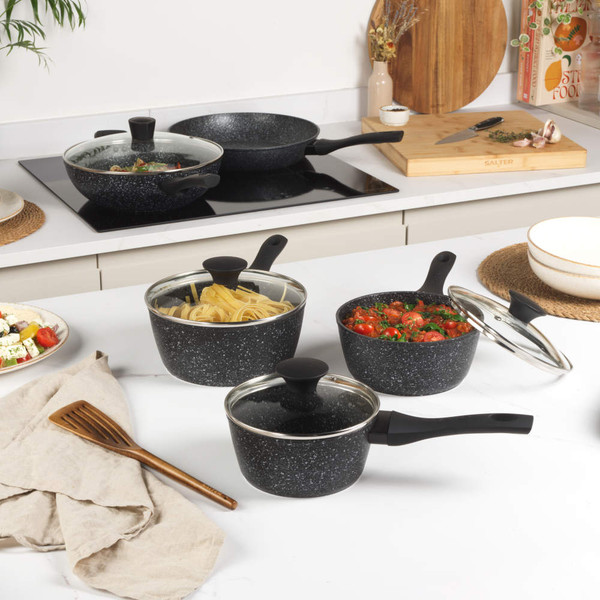 Set of non-stick black pans with cooked dishes, shown from above for product display
