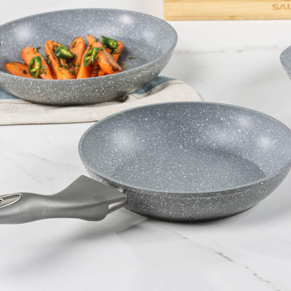 Grey non-stick frying pan with speckled finish on kitchen countertop