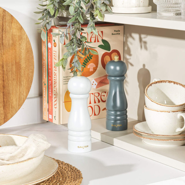Set of white and dark blue Salter salt and pepper mills on kitchen shelf