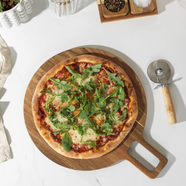 Stone-baked pizza with mozzarella and rocket on wooden board, top-down view