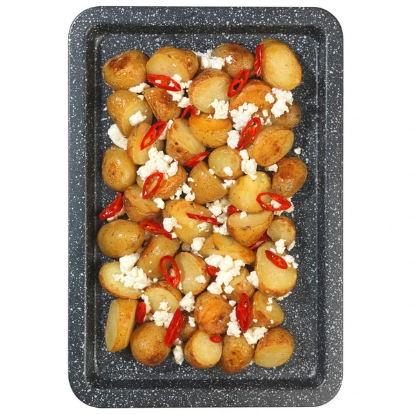 Roasted baby potatoes on tray with feta cheese and red chilli slices