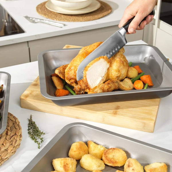 Three non-stick roasting tins shown with roast chicken and vegetables, perfect for Sunday lunch.