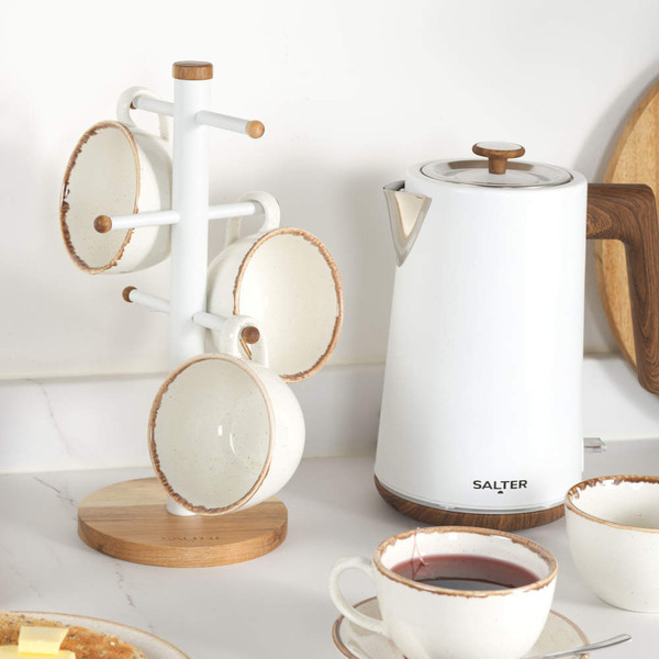 White ceramic mugs on wooden stand next to Salter white electric kettle with wood effect handle