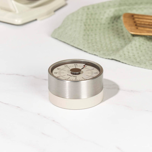 Cream and stainless steel mechanical kitchen timer on marble worktop