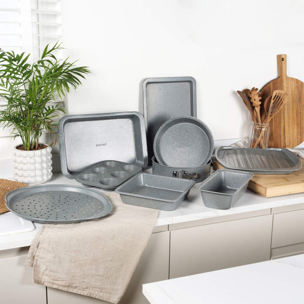 Set of grey non-stick bakeware including trays, tins, roaster and muffin pan on kitchen counter