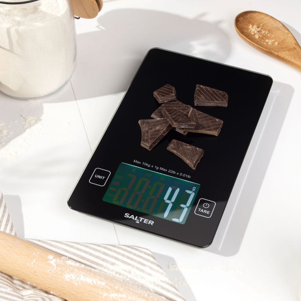 Digital kitchen scale with glass bowl of flour on worktop, black display, baking setting