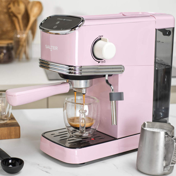 Portafilter with pink handle filled with ground coffee on white surface, for espresso machine