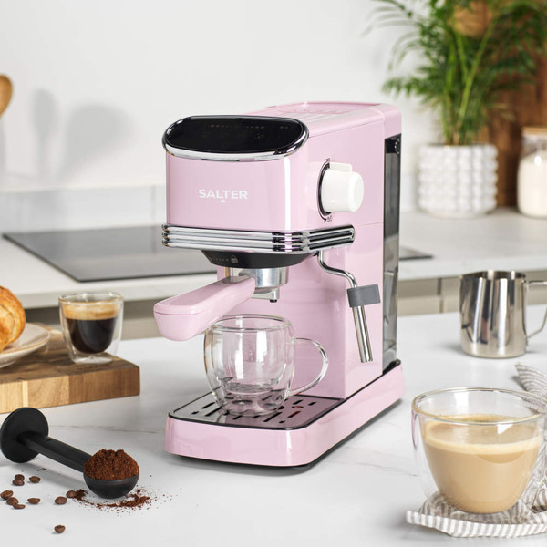 Pink Salter espresso coffee machine on kitchen counter with hand holding portafilter