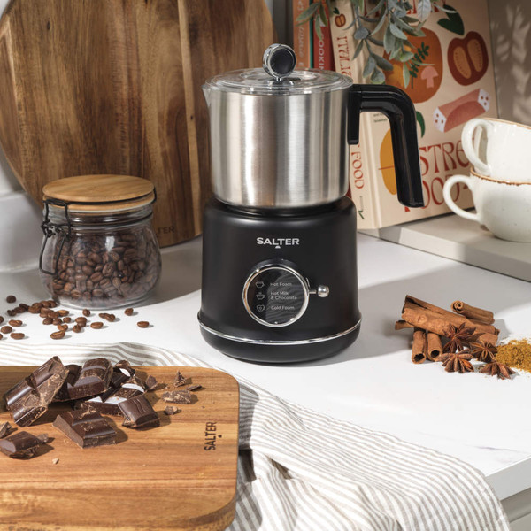 Stainless steel milk frothing jug with black plastic handle, shown empty from above.
