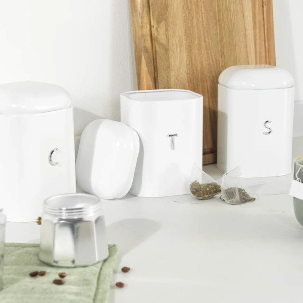 Set of three white storage tins for sugar, tea, and coffee with raised letters S, T, and U.