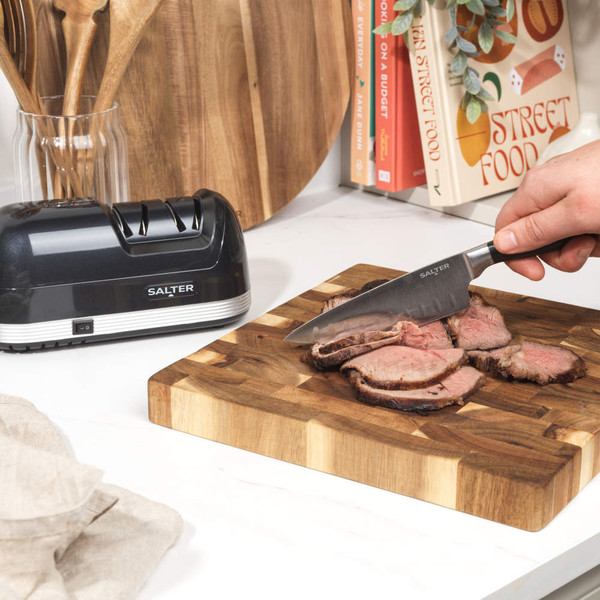 Black electric knife sharpener with Salter branding, shown at angle, 2-year guarantee badge