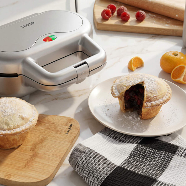 Silver Salter pie maker with fruit pies and baking ingredients on kitchen counter