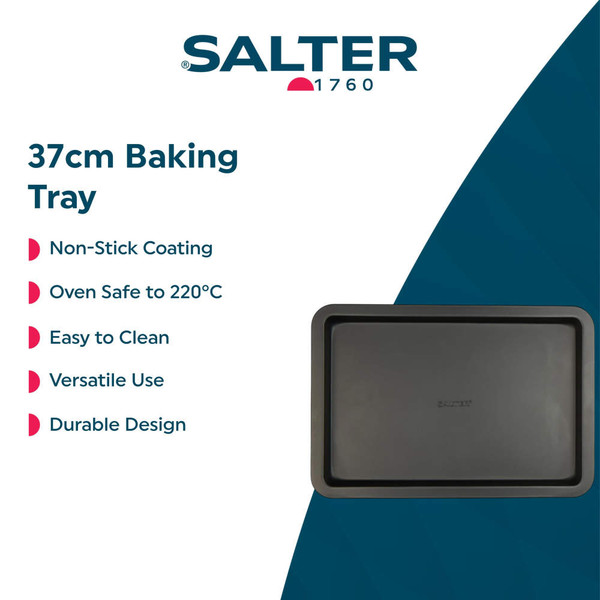 Black non-stick bakeware set with assorted cookies and cake, kitchen counter view