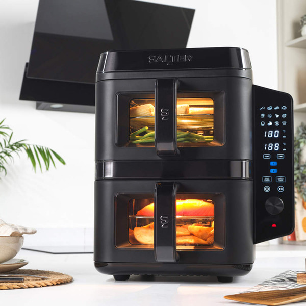 Black air fryer with salmon and vegetables showing separate racks for crisping and sides