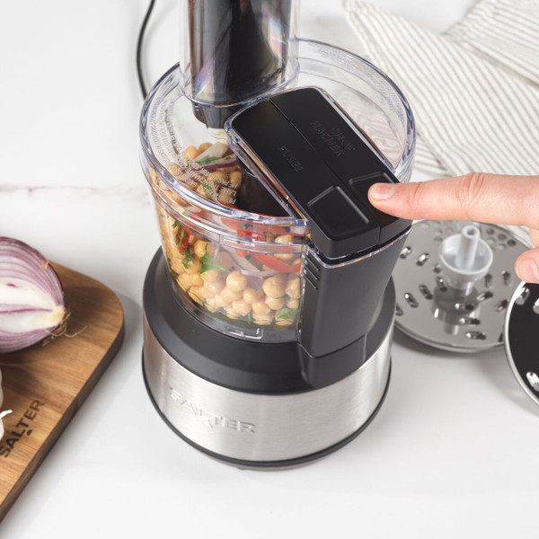 Black and silver food processor with slicing discs on kitchen counter