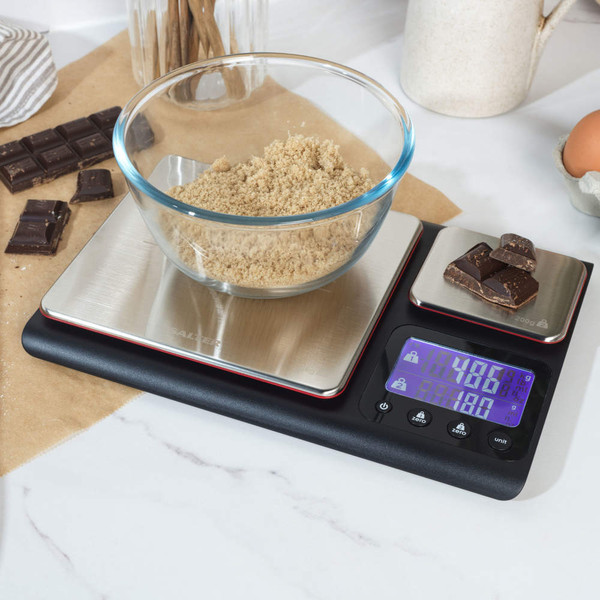 Digital kitchen scale with two platforms, bowl of brown sugar, chocolate pieces, and clear display