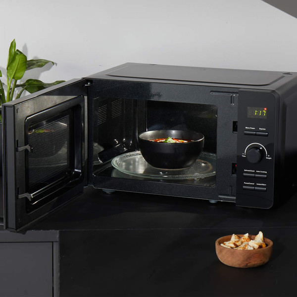Black microwave oven with digital controls on kitchen worktop