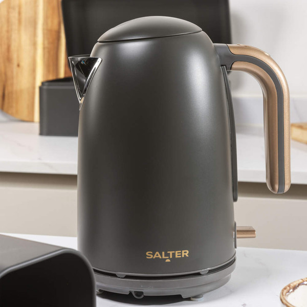 Four-slice black and gold toaster with one slice toasting, on kitchen counter