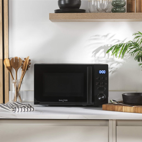 Black microwave oven on kitchen worktop with digital display and control panel