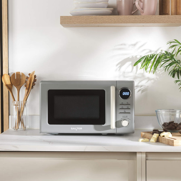 Grey microwave oven on kitchen counter with digital display, Salter branding visible