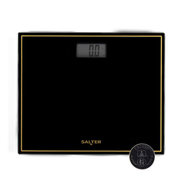 Black glass digital bathroom scale with gold trim, Salter branding, and battery shown