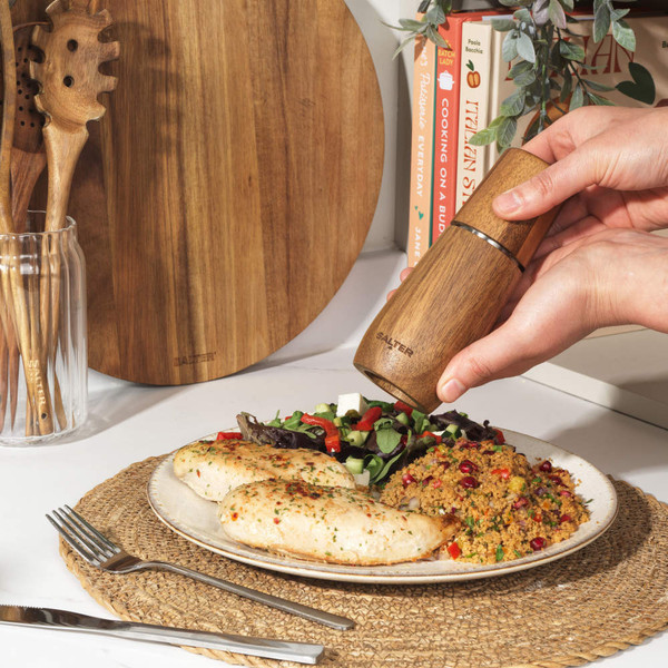 Salter wood salt or pepper grinder on kitchen shelf with cookbooks and glassware