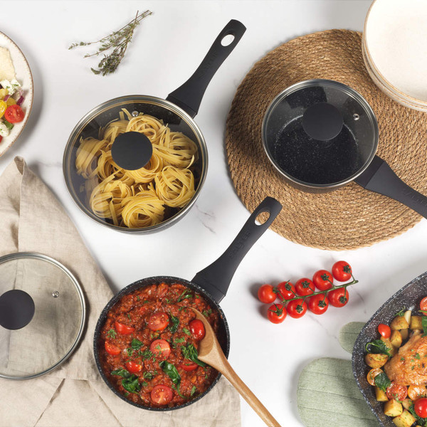 Set of Salter black-handled saucepans and frying pan in use, view from above
