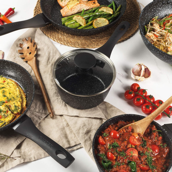 Set of black speckled non-stick cookware with assorted meals, shown from above