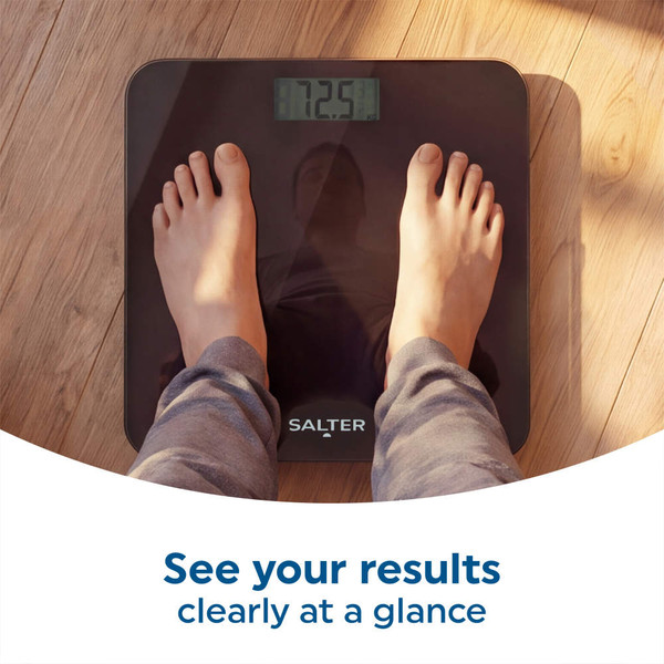 Black digital bathroom scale with feet on display