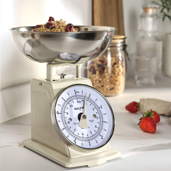 Cream mechanical kitchen scale with bowl, showing oats and berries.