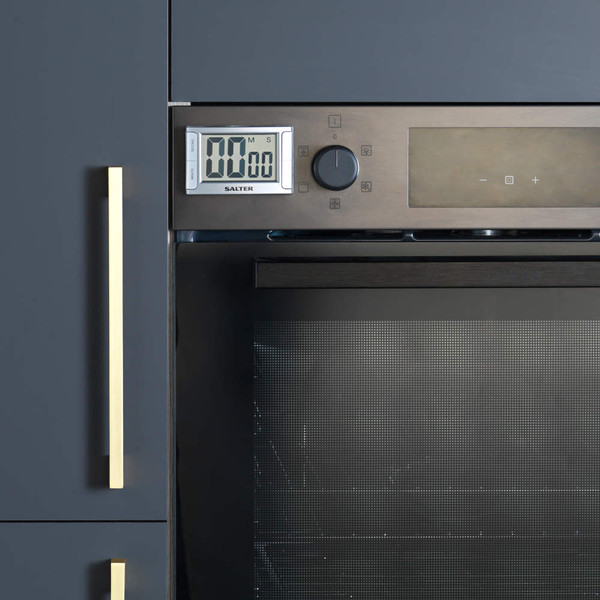 Digital kitchen timer attached to oven, shown in modern dark cabinetry.