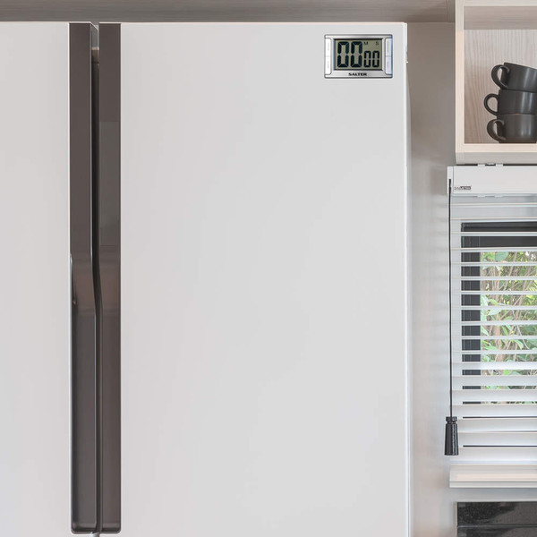 White fridge freezer with digital timer panel, shown closed in modern kitchen.