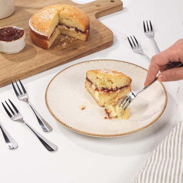 Silver dessert fork with three prongs, shown on white background