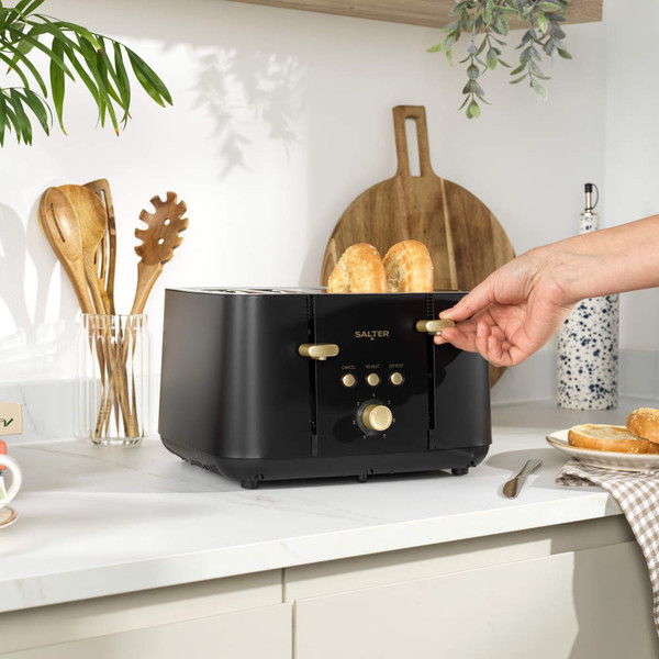 Black and gold four-slice toaster with bagels and bread toasting, angled view