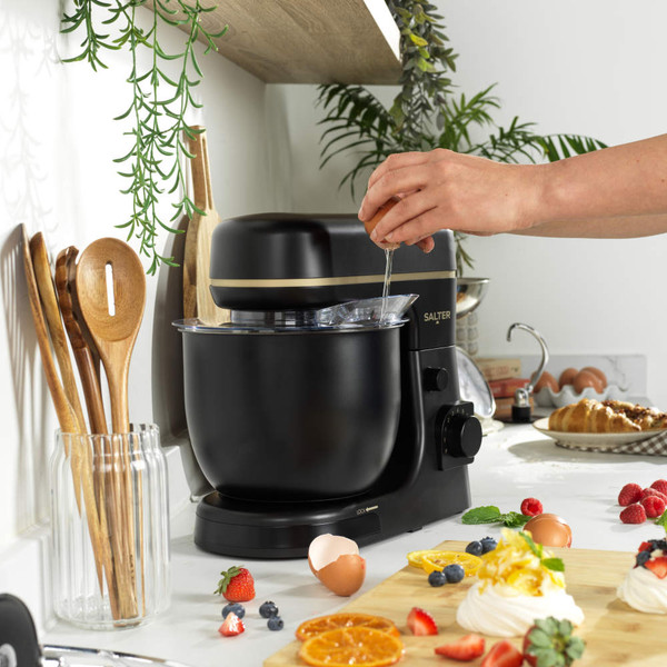 Black and gold stand mixer with whisk, dough hook, and beater attachments.