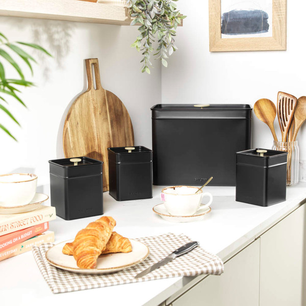 Set of black metal kitchen storage canisters on countertop