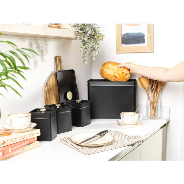Black bread bin with loaf of bread, modern kitchen setting
