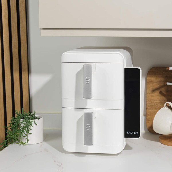 White dual zone air fryer with open drawer showing cooked chicken, control panel lit