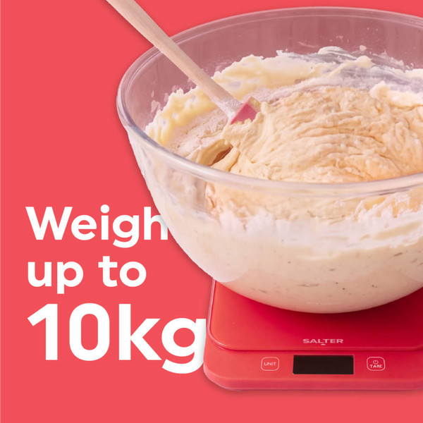 Red digital kitchen scale with five strawberries on top, shown on a white surface.