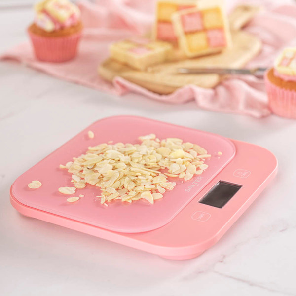 Pink digital kitchen scale with flaked almonds, shown for baking or cooking