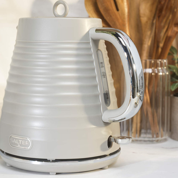 Taupe ribbed electric kettle being poured, showing Salter logo on handle