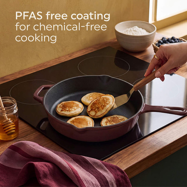Red cast iron skillet with baked eggs coming out of oven, hands with red oven gloves visible