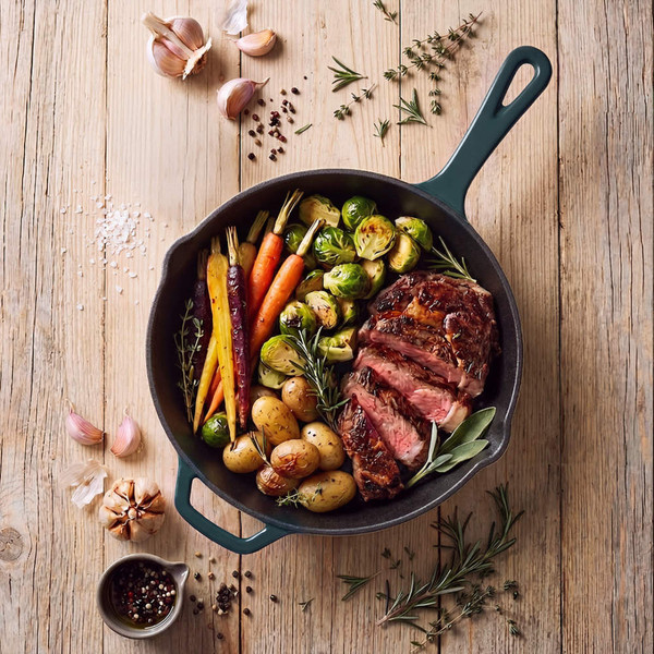 Cast iron pan with roast beef, colourful carrots, potatoes and Brussels sprouts
