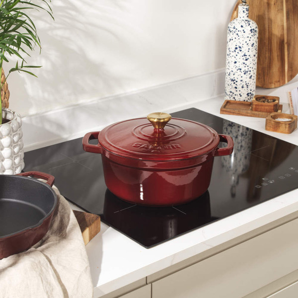 Red cast iron casserole dish with gold knob, seen from above