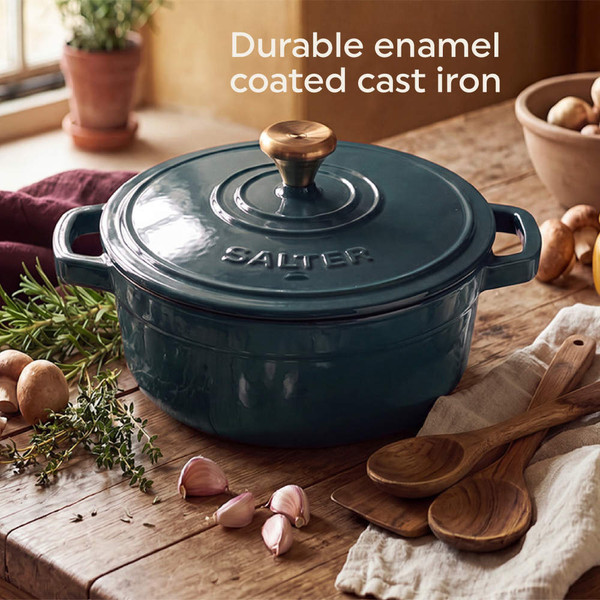 Green cast iron casserole dish with potato bake, shown being served in a kitchen