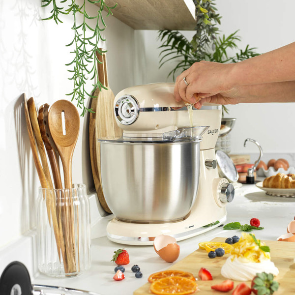 Cream stand mixer with stainless steel bowl and beater attachment, shown from side